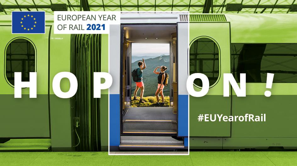Euroopan rautateiden teemavuoden mainoskuva, jossa on juna ja kaksi ihmistä reput selässä. Kuvassa lukee englanniksi ”Hyppää kyytiin!” Kuvassa on myös kerrottu teemavuoden sosiaalisen median aihetunniste #EUYearofRail