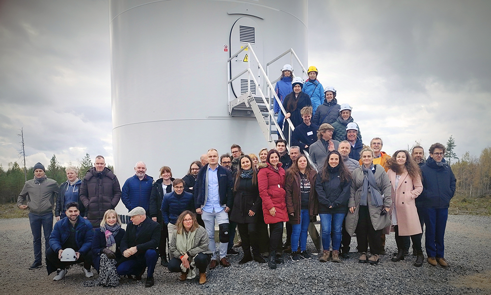 Biowind-hankkeen vierailijat ryhmäkuvassa tuulivoimalan portailla.