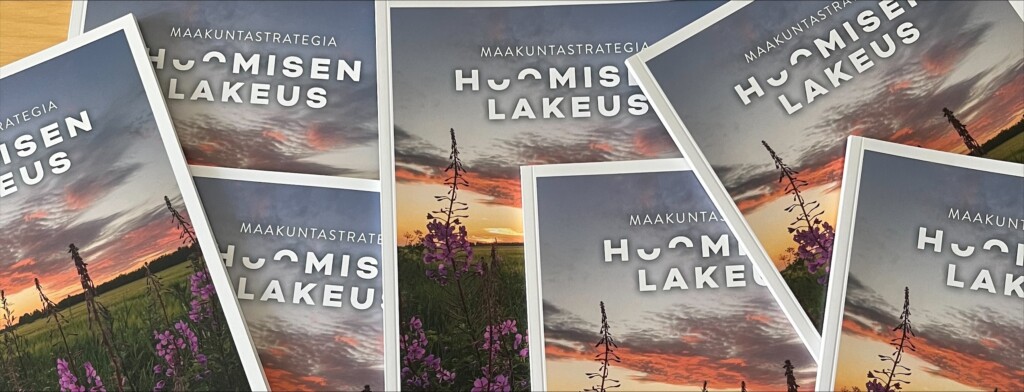 Maakuntastrategia-asiakirjoja limittäin ja lomittain pöydällä.