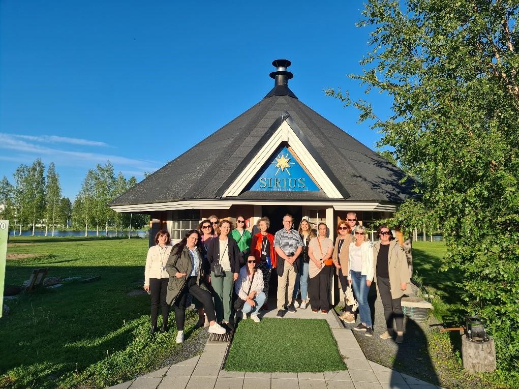 Ryhmäkuva järven rannalla, kodan edustalla. Group photo on the lake shore, in front of the hut.