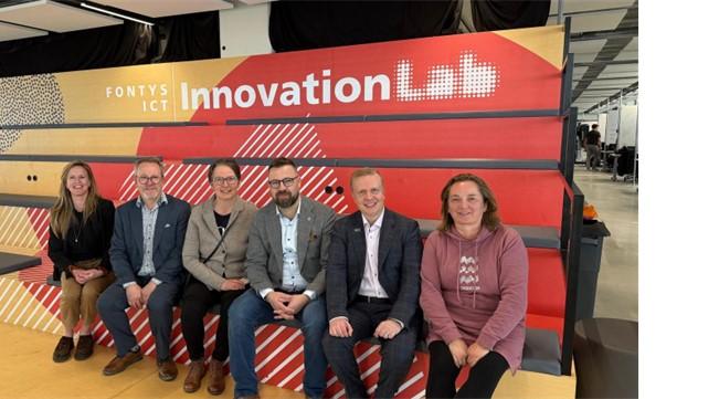 Matkalle osallistuneita henkilöitä istumassa "Innovation Labin" edessä.
